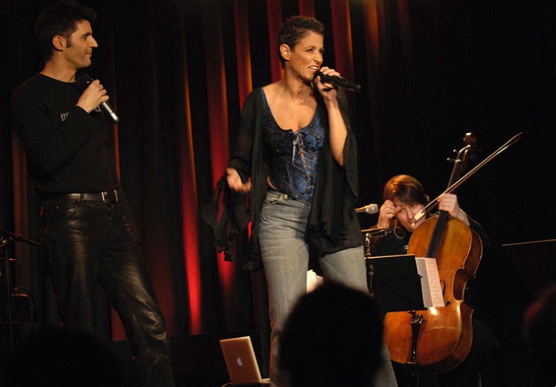 Roger Stein und Sandra Kreisler gemeinsam auf der Bühne, rechts die Cellistin – Wortfront live