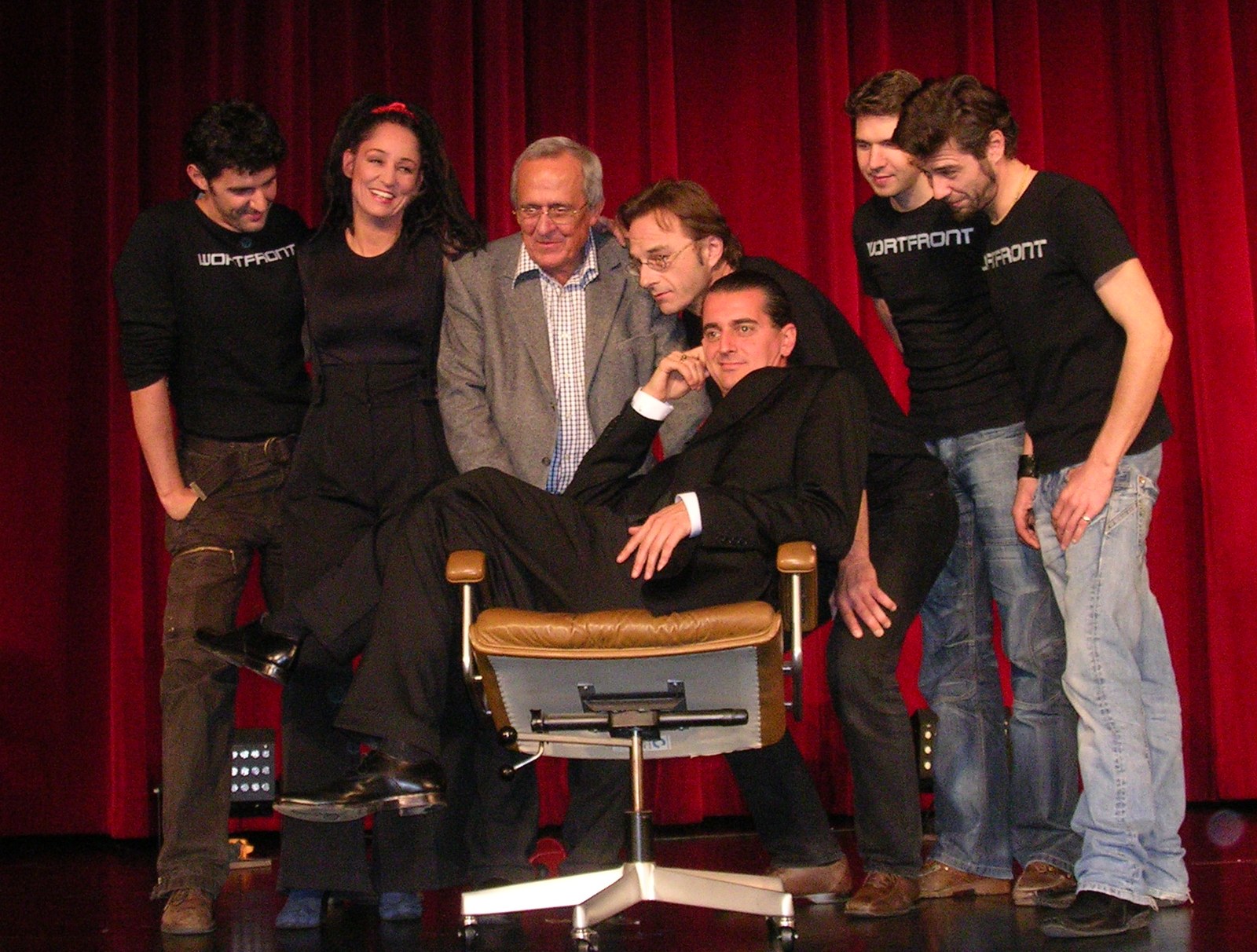 Gruppenfoto auf der Bühne der Lichtburg: Wortfront mit Dieter Hildebrandt, Fritz Eckenga und Hagen Rether im Bürostuhl
