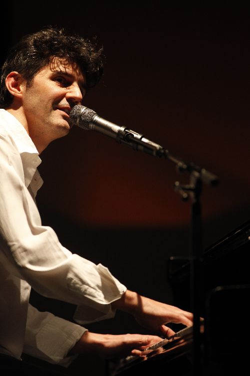 Roger Stein singt am Flügel ins Mikrofon